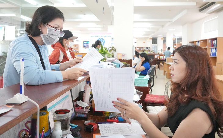 Người dân làm thủ tục giải quyết bảo hiểm tại Bảo hiểm xã hội TP.HCM - Ảnh: HỮU HẠNH